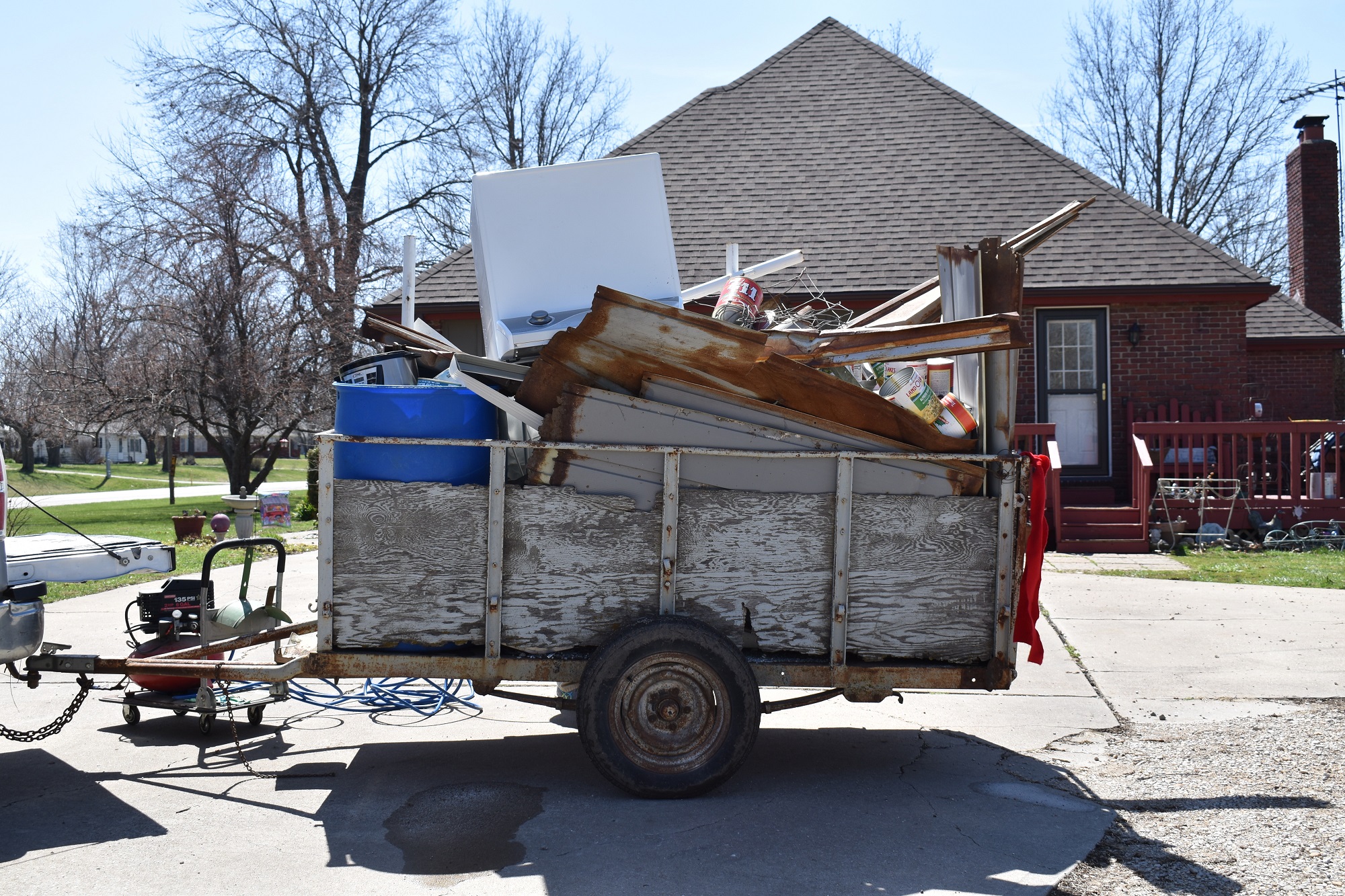 Old trailer loaded with scrap metal, broken appliances, and miscellaneous junk representing professional junk removal services Kent WA.